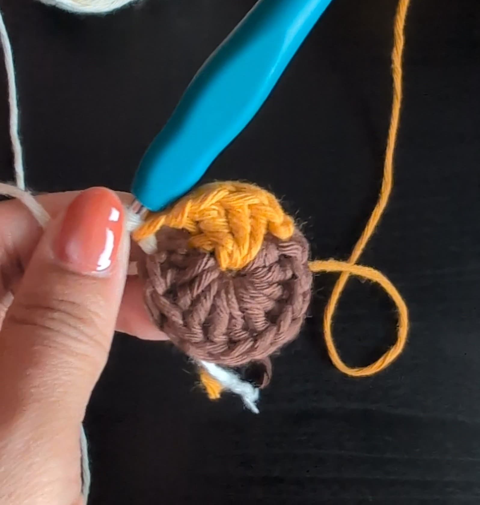 Round 1 of the diya motif, with a brown base and yellow flame
