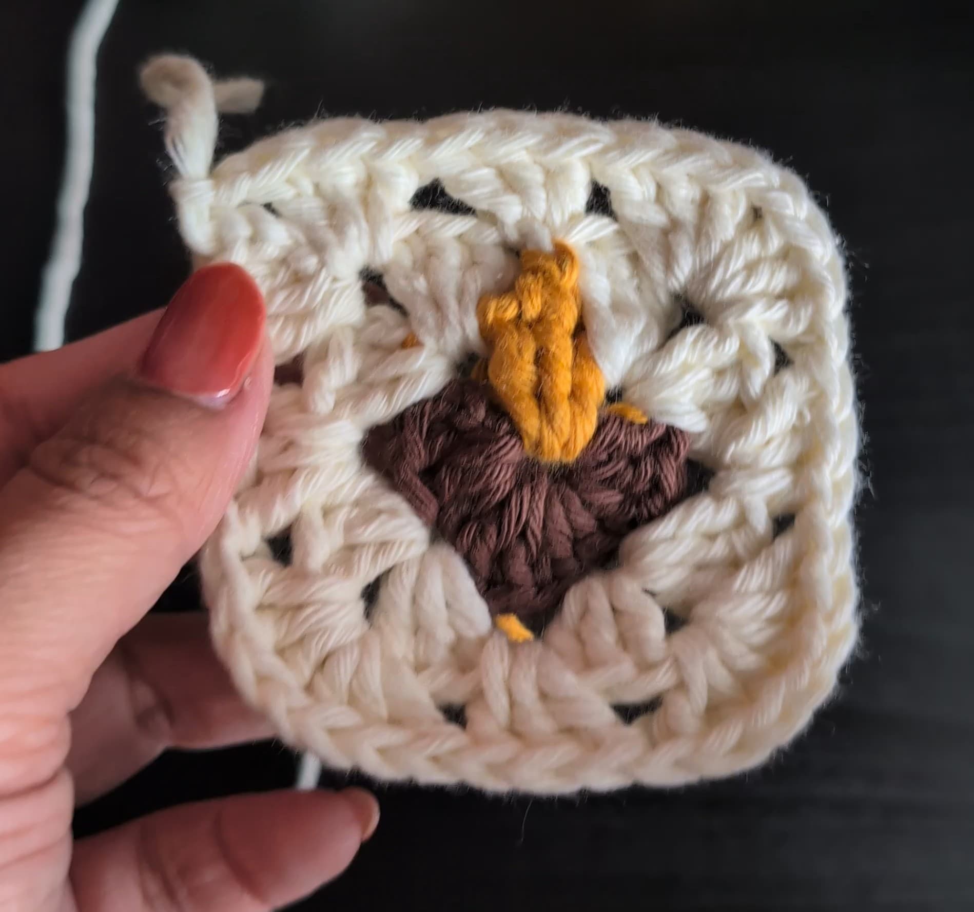 Round 3, the finished diya granny square with an off-white border